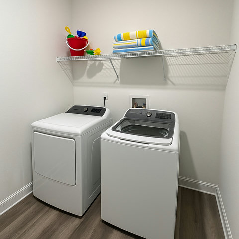 Washer dryer with beach towels and sand toys