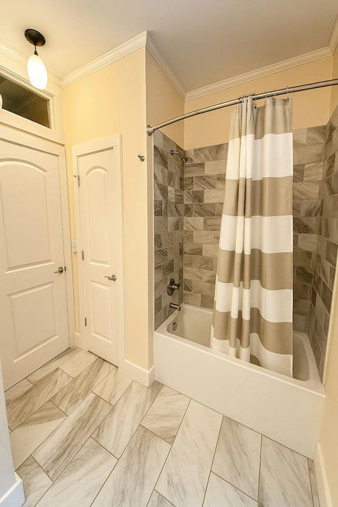Guest bath with striped curtain and tile tub