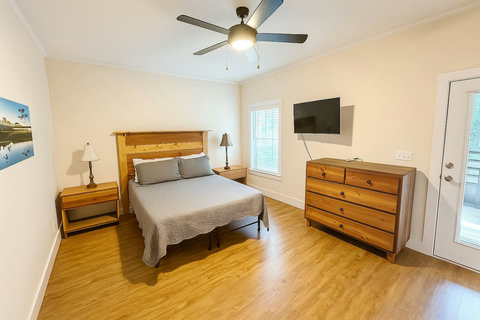 Queen bedroom with wood headboard and porch door