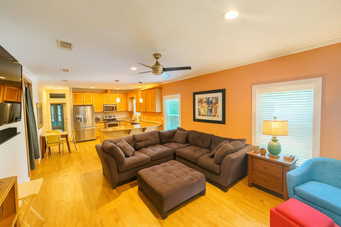 Living room opening to kitchen and yellow dining chairs