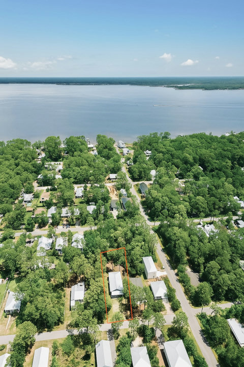 Home highlighted near bay in wooded neighborhood