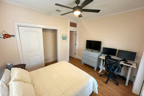 Bedroom workspace with TV and coastal wall art