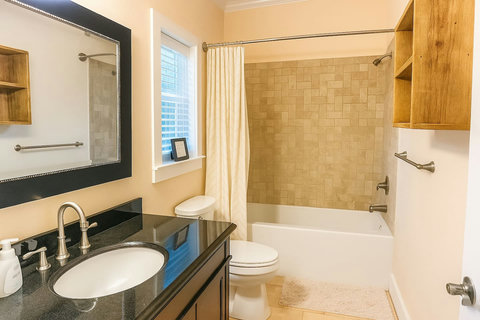 Bathroom with tub-shower and dark vanity