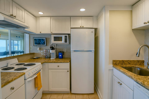 Fully equipped kitchen with white cabinets and granite