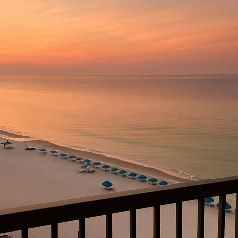 Sunset balcony view over blue beach umbrellas