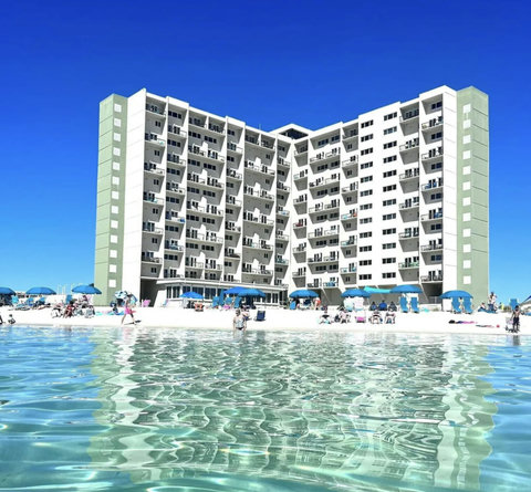 Beachfront condo towers over turquoise shoreline
