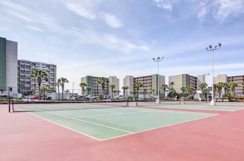 On-site tennis courts under bright blue skies