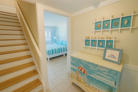 Coastal hallway with beach-scene cabinet and shells