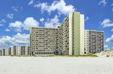 Pinnacle Port towers rise above white sand beach