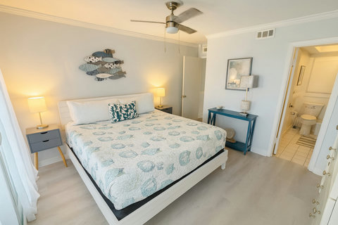 Shell-pattern bed with ensuite bath beyond doorway
