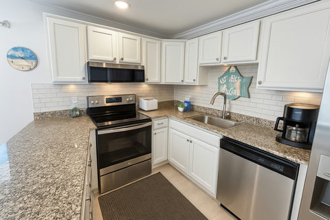 White shaker kitchen with subway tile and coffee maker