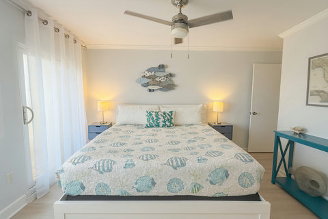 Coastal bedroom with fish wall art and soft light