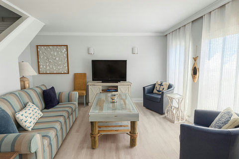 Nautical living room with navy chairs and anchor pillow