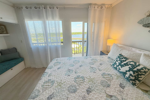 Bedroom balcony doors overlooking calm lake waters