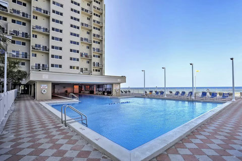 Resort pool with lounge chairs and Gulf beyond