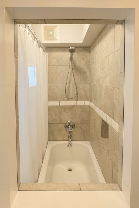 Tub-shower combo with stone tile and handheld spray