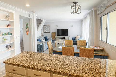 Wicker dining seats open to striped living room