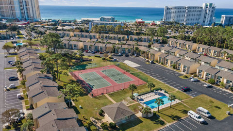 Aerial view of tennis courts, pool, and nearby Gulf