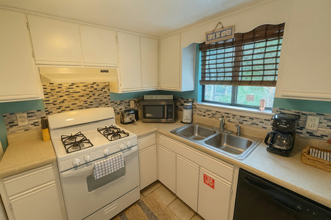 Teal kitchen with mosaic backsplash and gas range