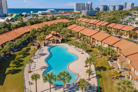 Kidney-shaped community pool amid palm-lined townhomes