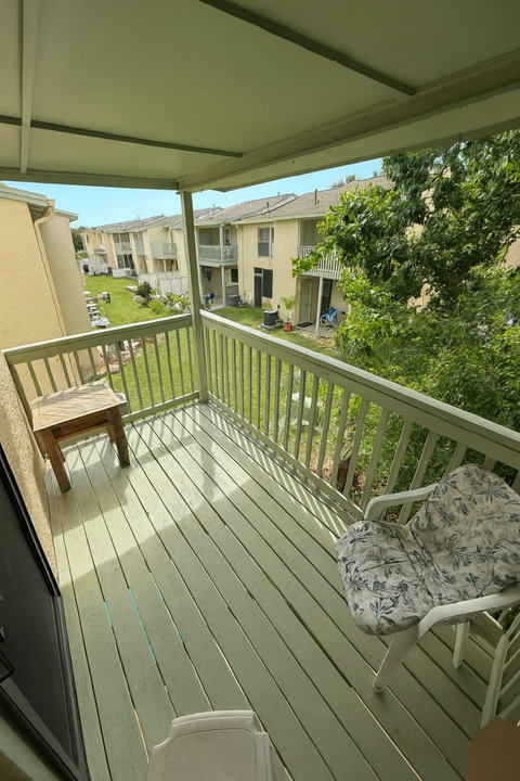 Private balcony seating overlooking grassy courtyard