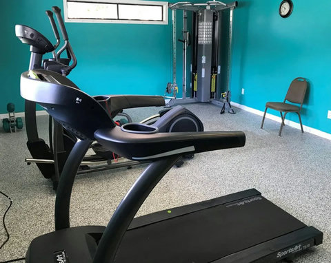 Fitness room with treadmill, elliptical, and weight station