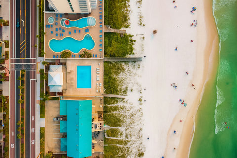 Aerial beachfront pools with boardwalks to white sand