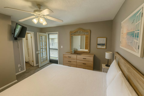 Primary bedroom with balcony door and ensuite bath