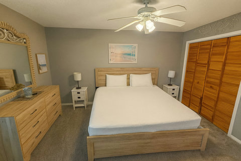 Bright bedroom with beach art and louvered closets