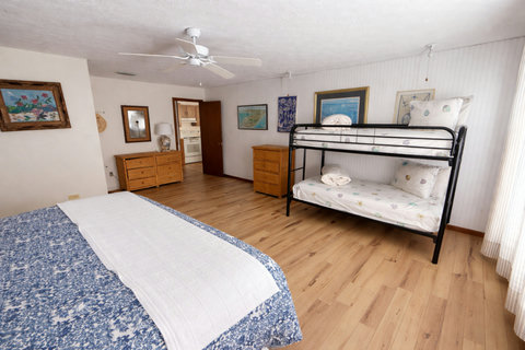 Spacious bedroom with king bed and metal bunks