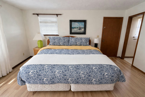 King bed with coastal linens and beach artwork