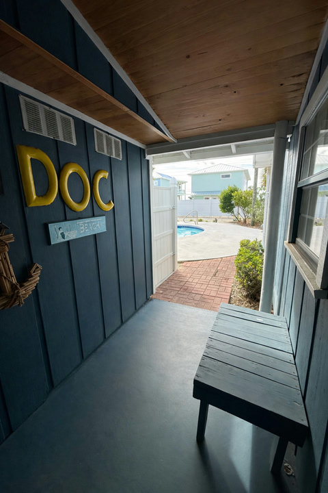Coastal porch entry opening to the private pool