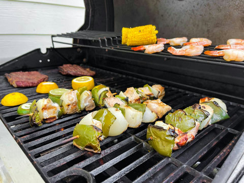 Grill loaded with kabobs, steaks, and shrimp