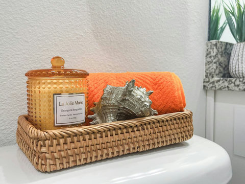 Spa basket with candle, seashell, and orange towel