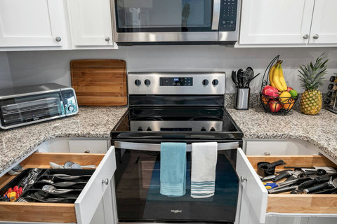 Stocked kitchen range with open utensil drawers