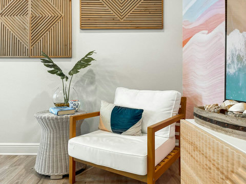 Wood-frame armchair nook with coastal wall art