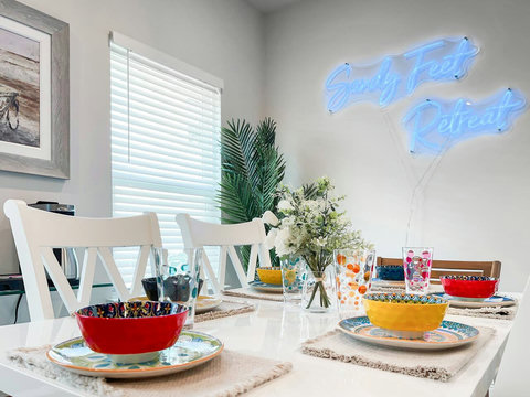 Colorful place settings under Sandy Feet neon sign