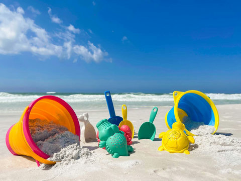Colorful sand toys on sugar-white beach sand