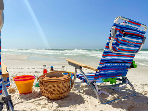 Striped beach chair facing emerald Gulf waves