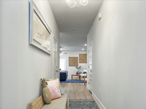 Sunny entry hall with pineapple pillow and bird art