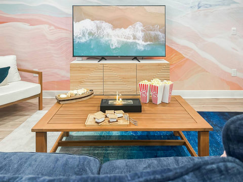Movie-night setup with popcorn and beach mural TV