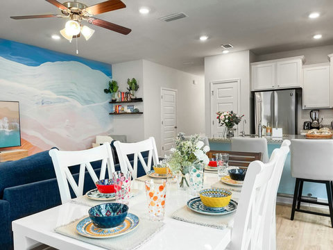 Open dining table with wave mural and kitchen bar