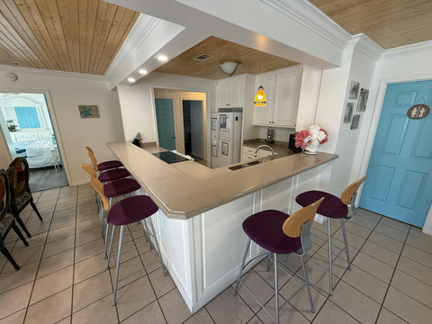 Wraparound breakfast bar with six purple bar stools