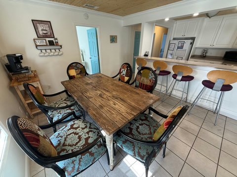 Eclectic dining table beside coffee station and kitchen