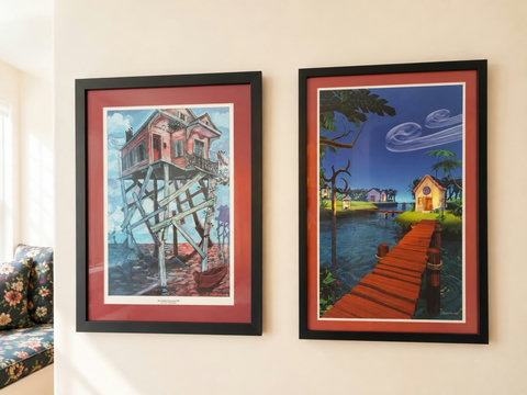 Framed coastal art of stilt house and glowing pier
