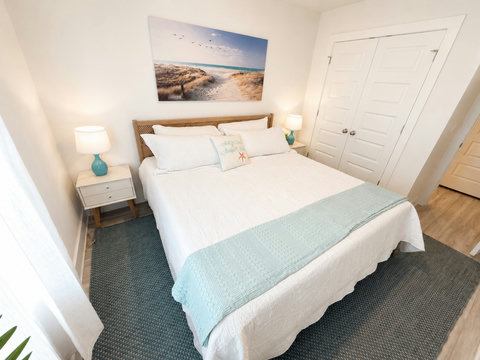 Airy bedroom with woven headboard and beach art