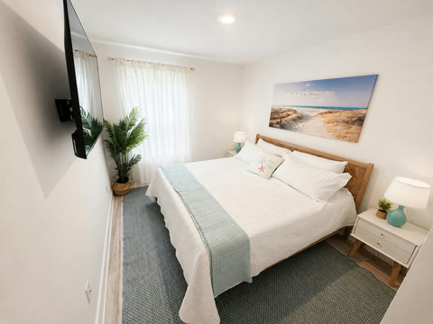 Coastal bedroom with beach art and teal lamps