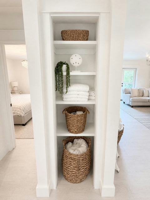 Hallway shelves stocked with towels and cozy blankets