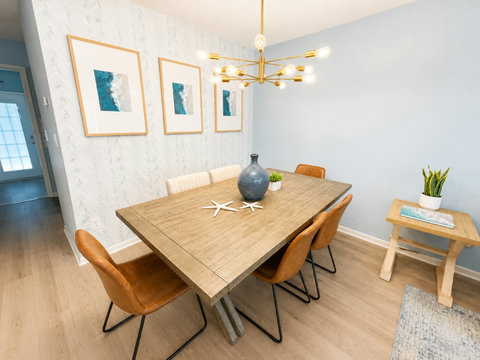 Dining table with wave art and brass chandelier