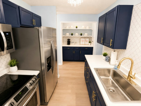 Navy galley kitchen with gold hardware and coffee bar
